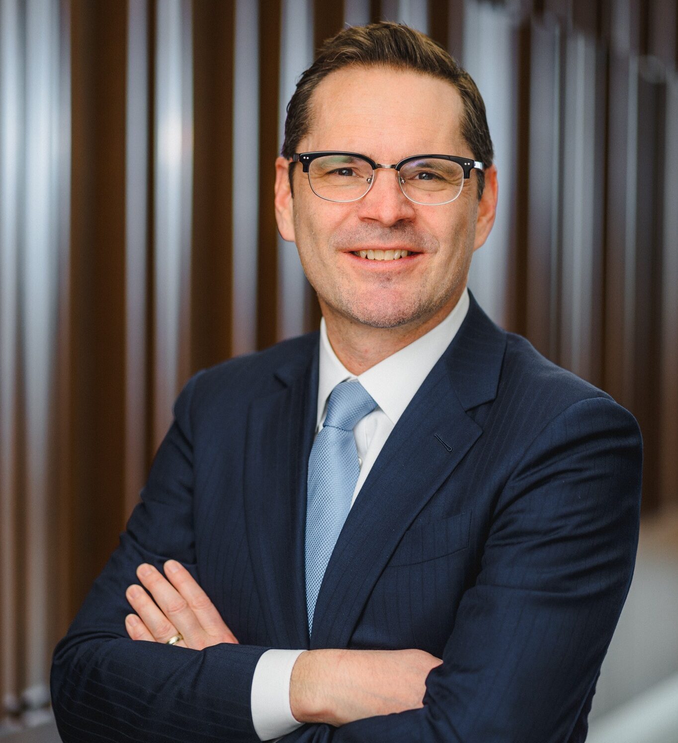 Professor Chris Peterson, a white man with dark brown hair wearing black-rimmed glasses and a navy suit coat