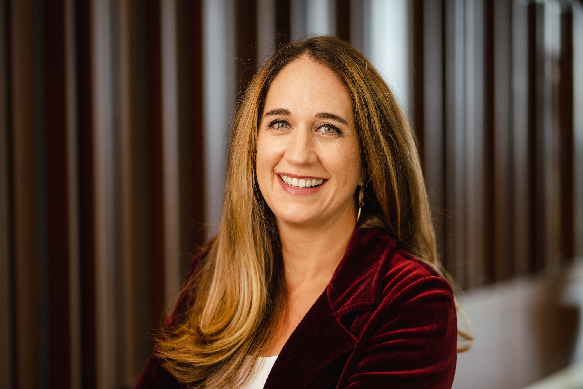 Professor Teneille Brown, a white woman with long, light-brown hair wearing a burgundy velvet blazer